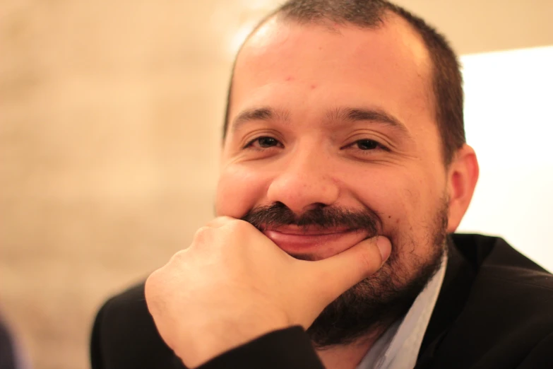 a man smiles into the camera while posing for a po