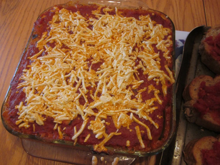 a casserole dish full of red sauce and cheesy cheese