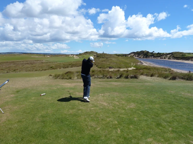 the man is playing golf on the very large lawn