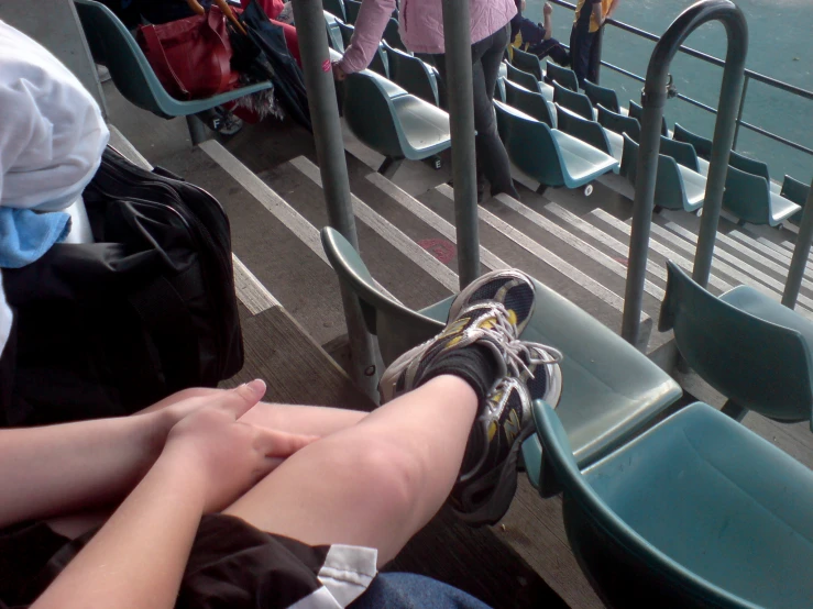 two people sitting on seats in the bleachers