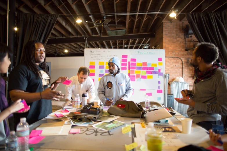 group of people working on project in room with white board