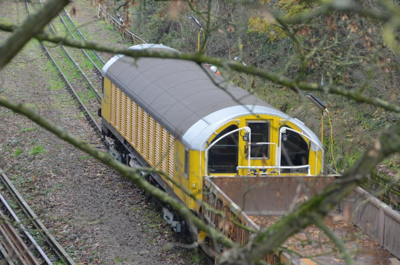 an old train traveling on a track through the forest