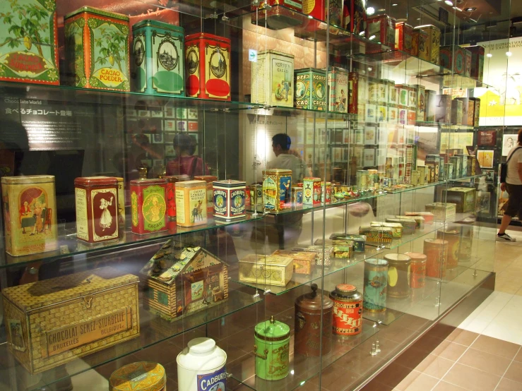 various vintage boxes are in a glass display case