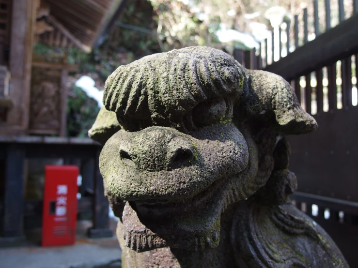 a stone sculpture of a goat and an asian structure