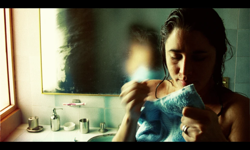 a woman brushing her teeth in the bathroom