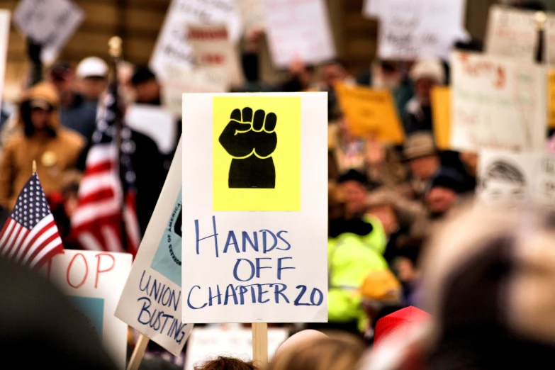 a group of protesters with signs and american flags