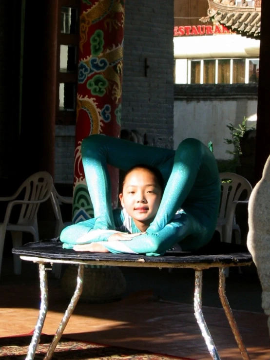 a person wearing a blue outfit sitting on a small table