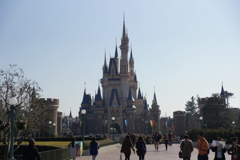 people walking in front of an ornate castle