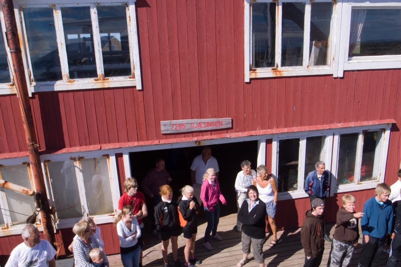 people are standing in a red building on a deck