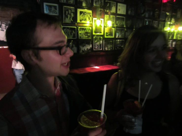 two people are sitting and drinking cocktails at the same time