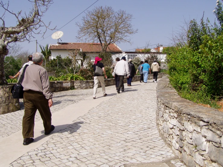 several people walking on a cobblestone path