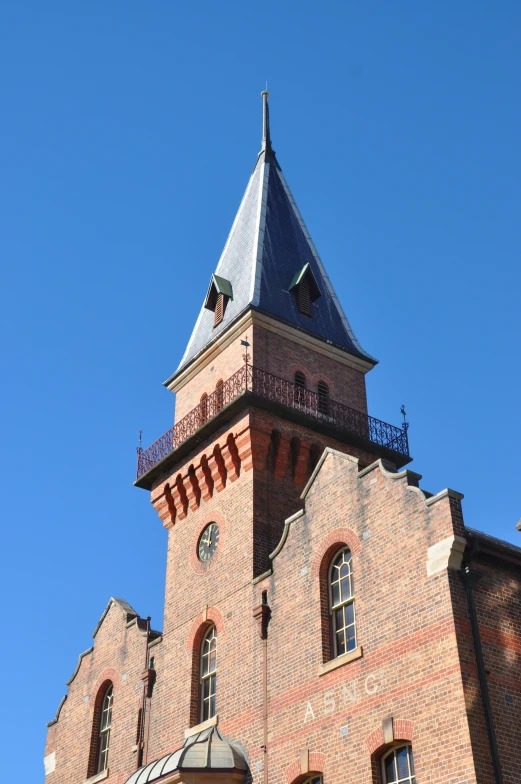 the clock is on a brick building and a blue sky in the background