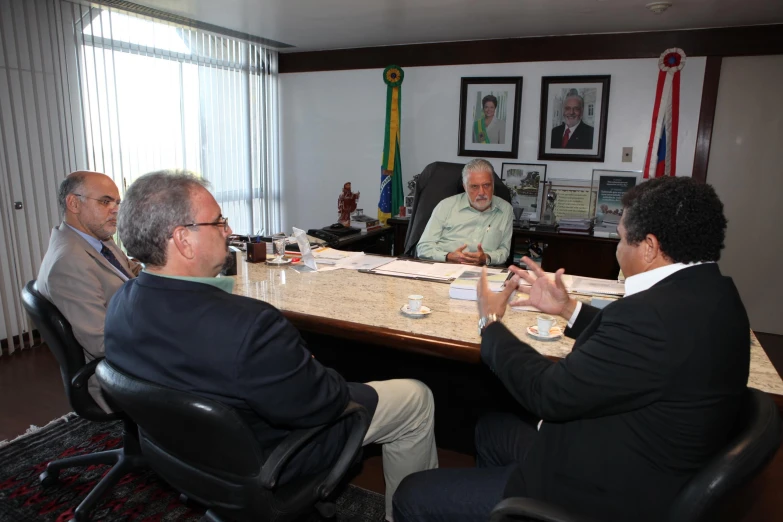 a bunch of people are gathered at a conference table