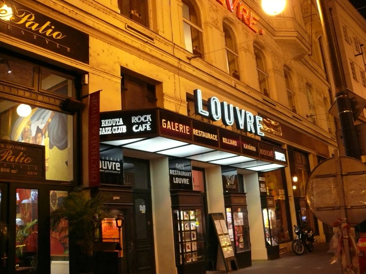 a restaurant called louvyre is lit up at night