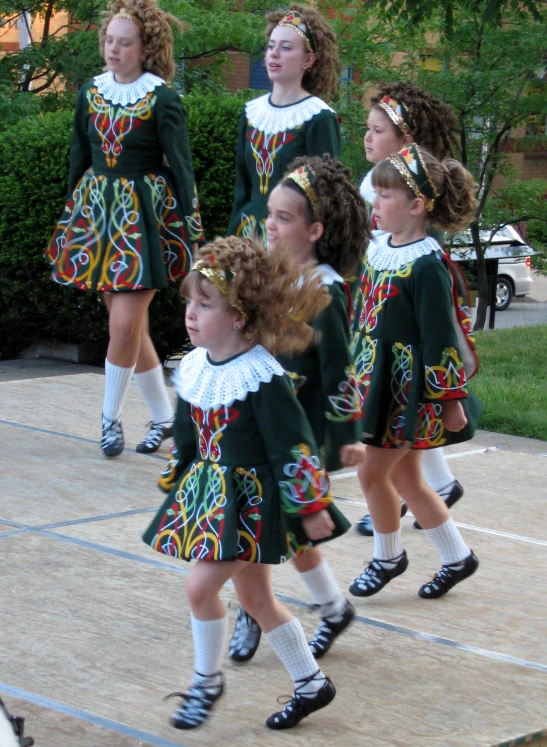 several girls are dressed in colorful clothes and dancing