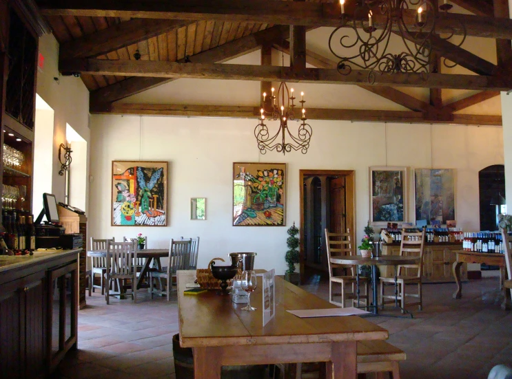 a dining room with chairs and tables with lights hanging from the ceiling