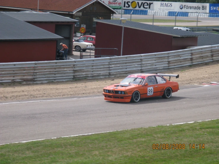 an orange car driving down the race track