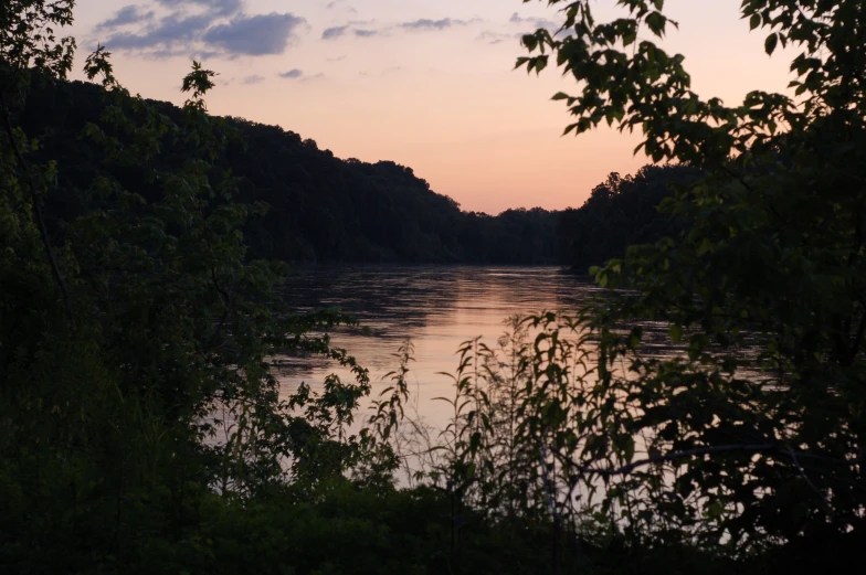 the sun is setting over the water at a river