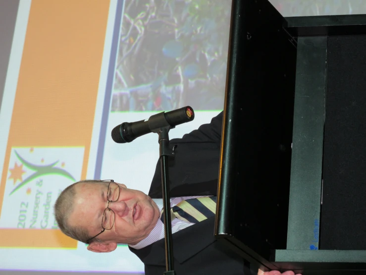 a man standing at a podium and giving a presentation