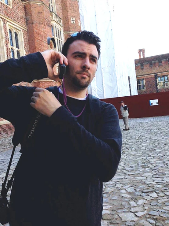 a man talking on the phone and holding a piece of wood