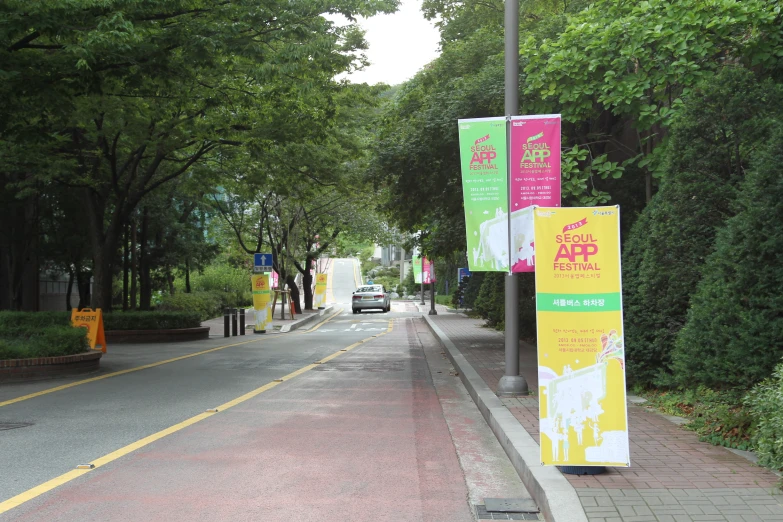 two banners and a car drive down a street