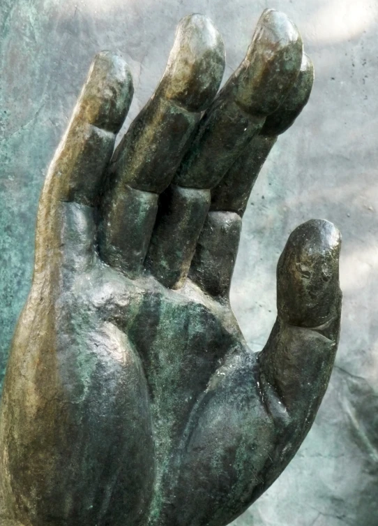 a bronze statue of a hand holding soing