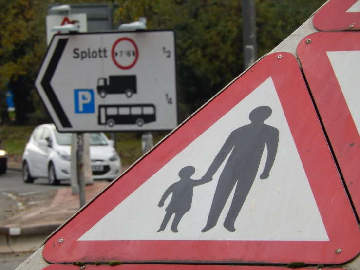 a close up of a sign with a person holding a child's hand