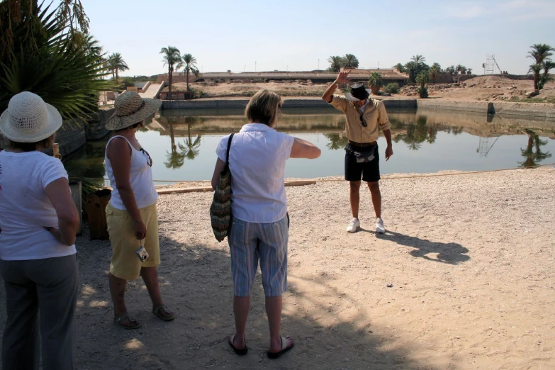 three people standing in front of water looking at soing