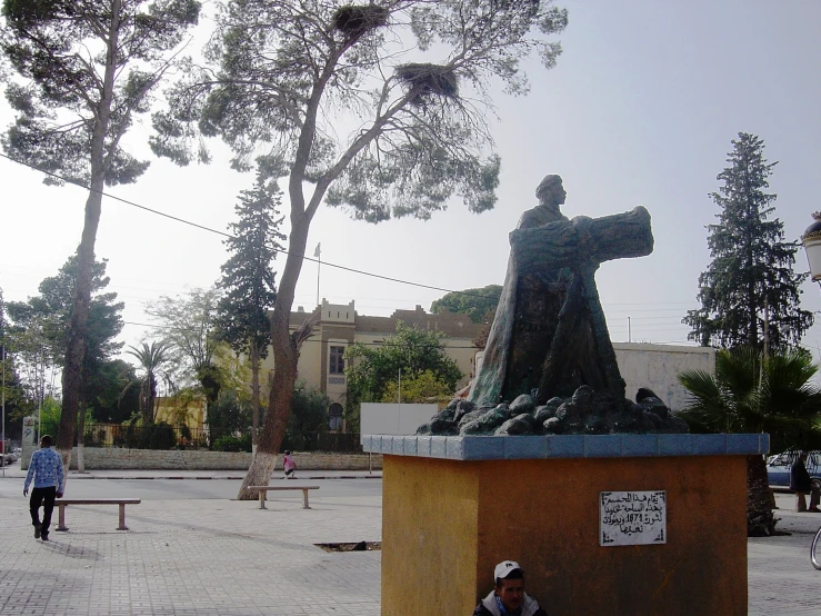 a woman sitting on a bench near a statue