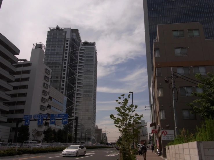 some buildings and some cars are driving down the street