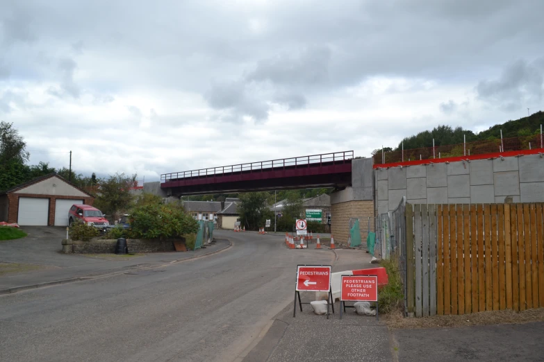 a bridge over a road with stop signs