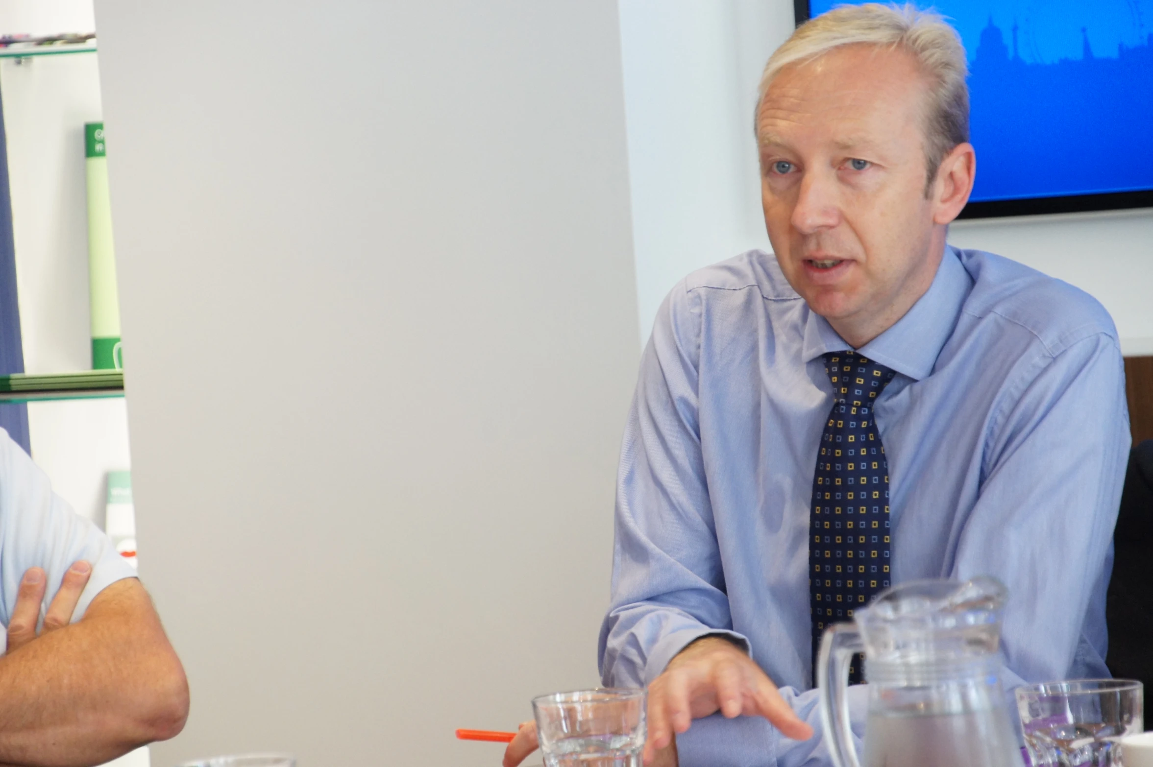 two men sitting at a table talking to each other