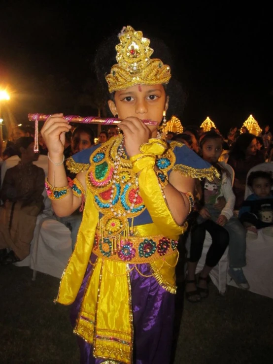 a little girl dressed in costume playing a flute