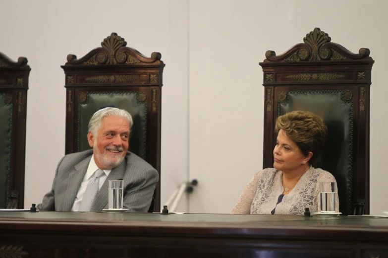 a woman talking into a microphone sitting next to a man