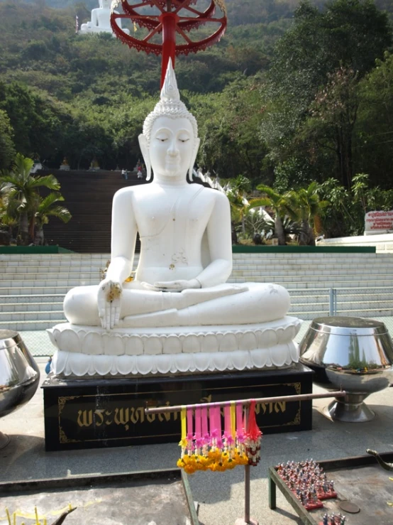 an ornate white statue stands in the shade in a temple