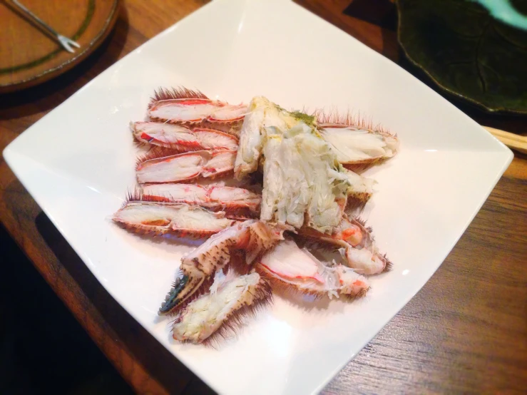 some crabs sitting on top of a white plate