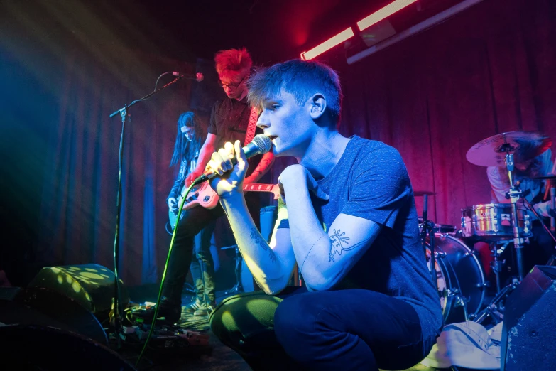 the singer is playing an instrument as the band performs