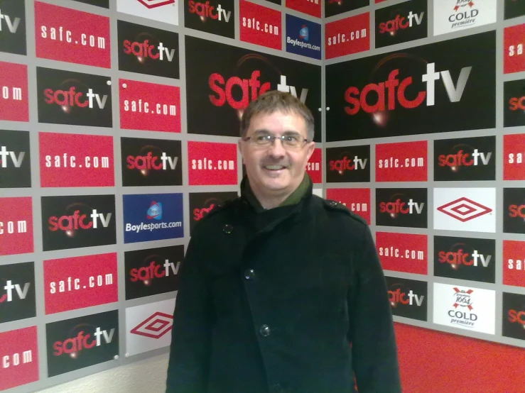 a man standing in front of a sign for softv