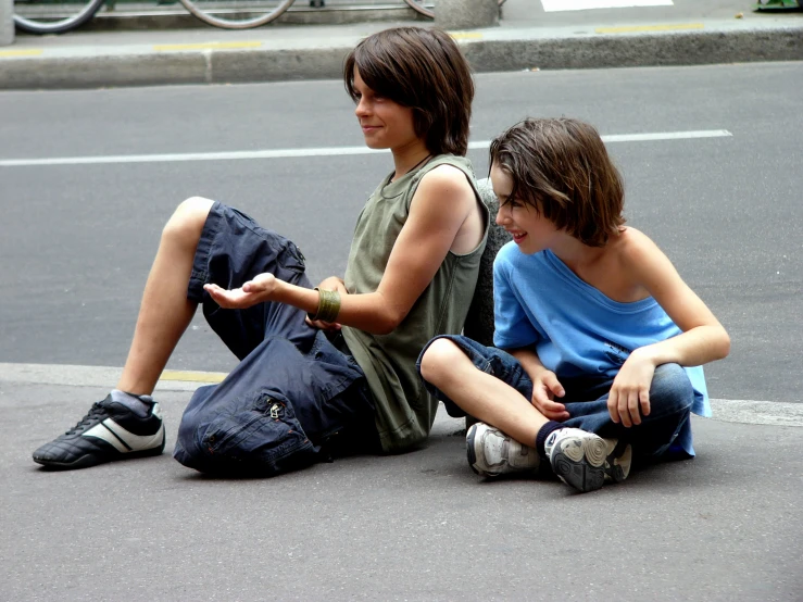 two small children sitting on the ground together