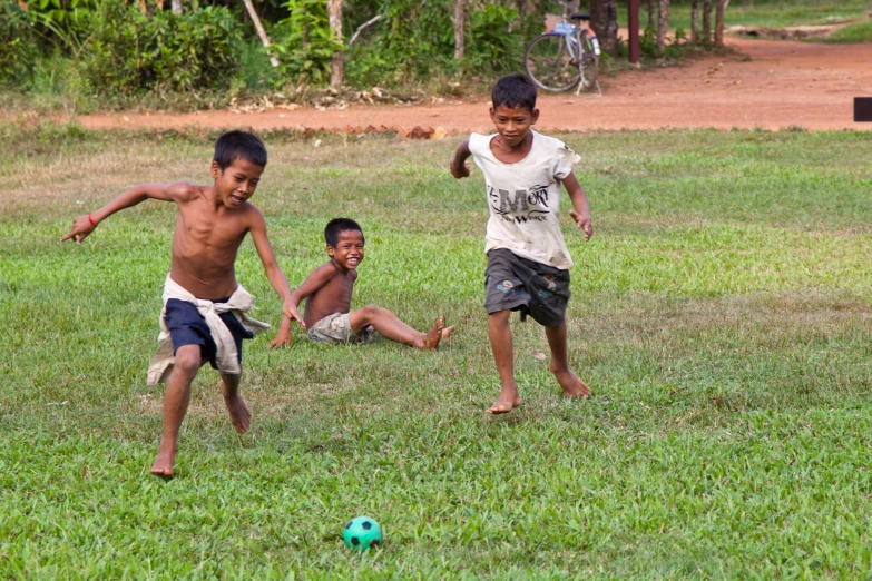 a group of children playing soccer in a field