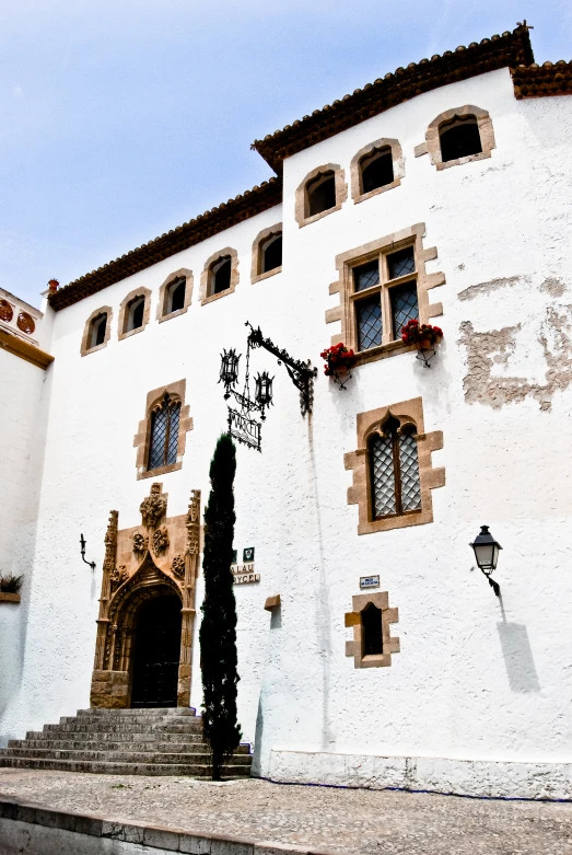 a large white building with some windows and a staircase in front