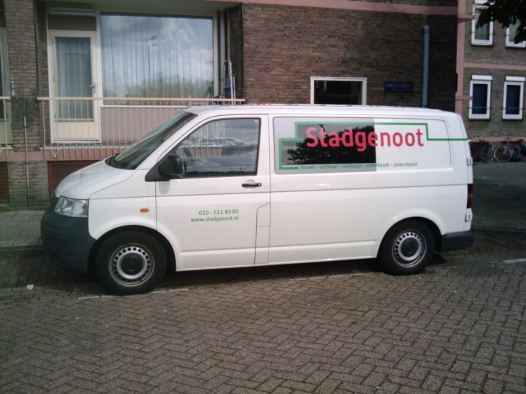 a white van parked on top of a brick road