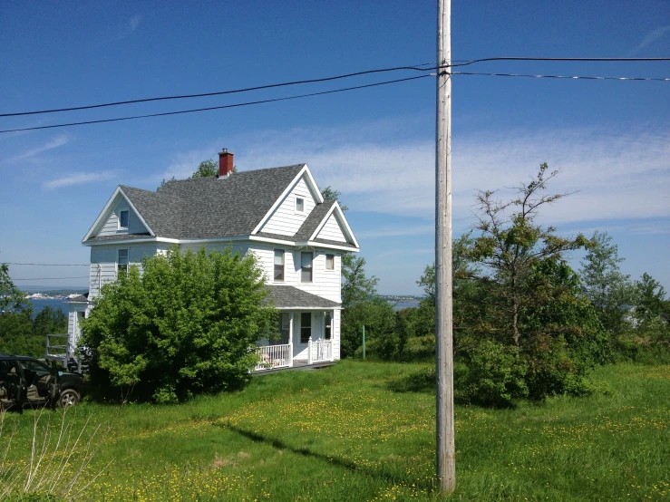 a large white house sitting on top of a lush green hillside