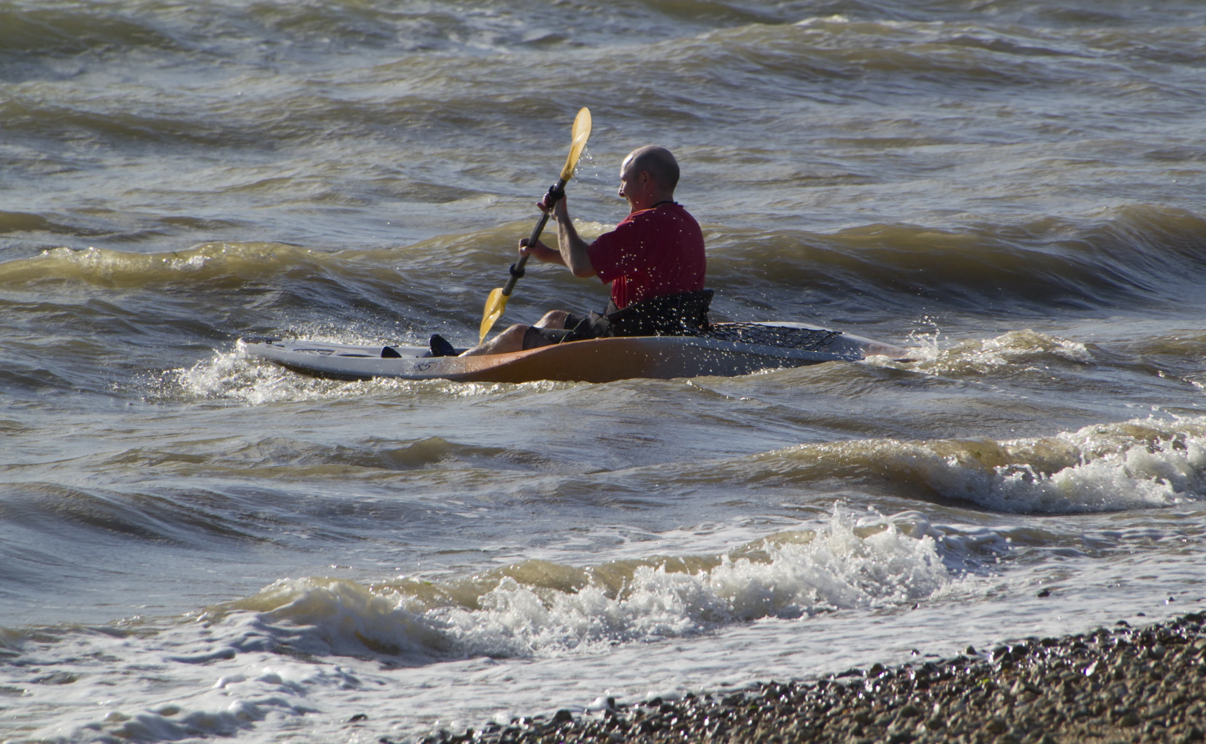 a man sitting on top of a kayak with paddles