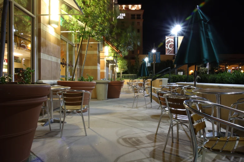 several patio seating and tables in front of some tall buildings