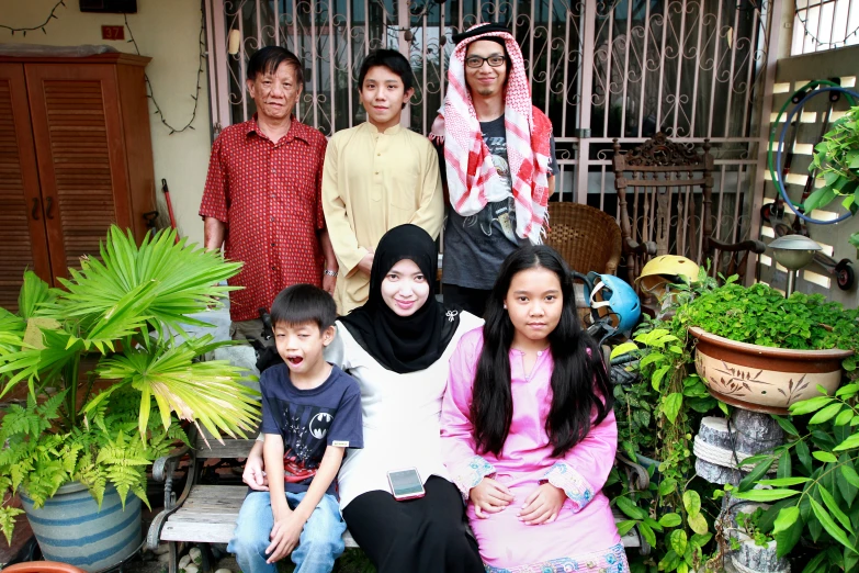 a woman and three children pose for a family po