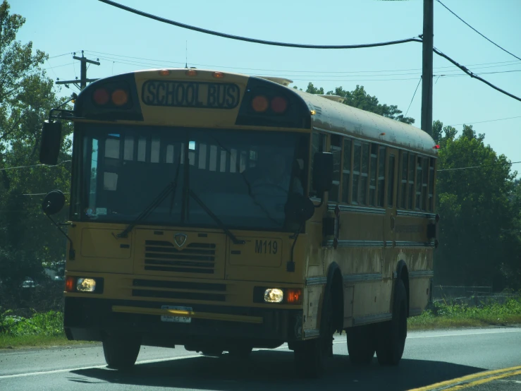 school bus going down the road near an electric pole