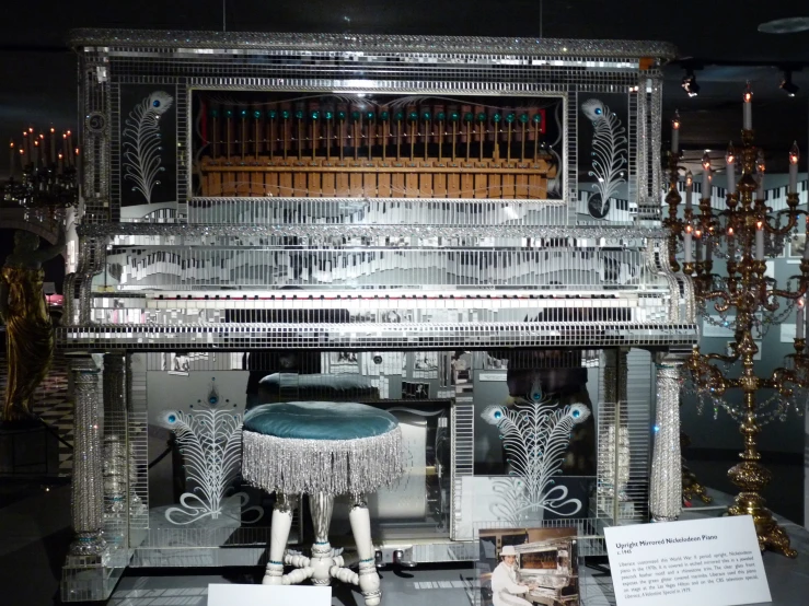 a silver piano with elaborate details and lights