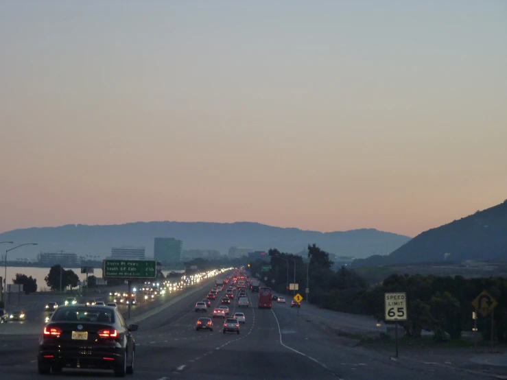 cars are seen travelling down the highway at sunset