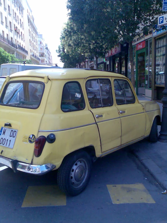 an old yellow mini van parked along the side of the road